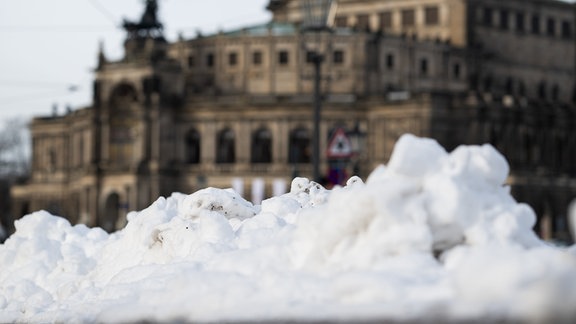 Ein Schneehaufen liegt am Vormittag auf dem Theaterplatz vor der Semperoper.