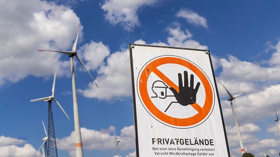 Schild "Betreten verboten" vor Windrädern