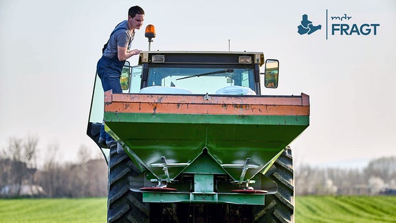 Bauer untersucht Traktor auf dem Feld.