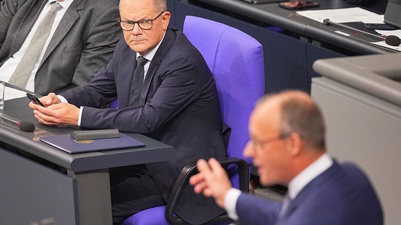 Friedrich Merz, CDU-Bundesvorsitzender und Unionsfraktionsvorsitzender, spricht nach der Regierungserklärung von Bundeskanzler Olaf Scholz (SPD, l) im Bundestag