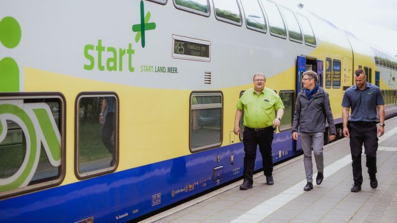 Menschen neben einer Regionalbahn