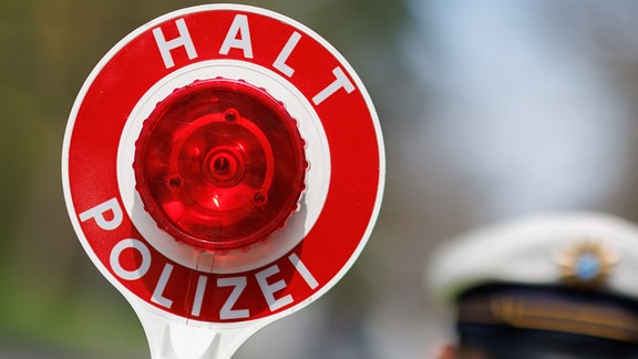 Ein Polizist zieht ein Fahrzeug mit seiner Kelle aus dem Verkehr. An rund 1800 Messstellen in ganz Bayern achten Polizei und Beschäftigte der Gemeinden sowie der kommunalen Verkehrsüberwachung auf Raserinnen und Raser. Vor allem wird aber auch dort kontrolliert, wo die Gefahr für Unfälle durch zu schnelles Fahren am gröÃten ist oder häufig zu schnell gefahren wird.