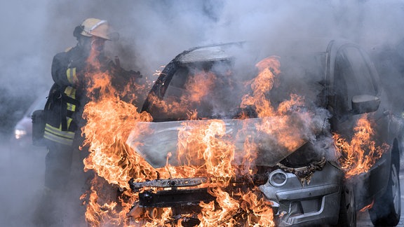 Feuerwehr löscht ein brennendes Auto