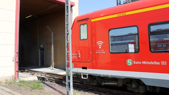 eine rote S-Bahn steht vor einem rot eingerahmten Tor