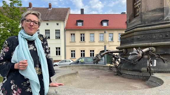 Bad Schmiedebergs Bürgermeisterin Heike Dorczok vor dem leeren Brunnen am Marktplatz