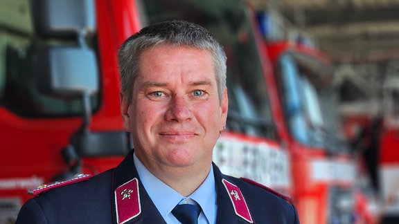 Ein Feuerwehrmann in Uniform steht in einem Gerätehaus in Salzwedel