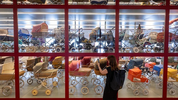 Eine Besucherin des Kinderwagenmuseums Zeitz fotografiert im neuen Schaudepot. Um noch mehr Exponate des Sammlungsbestandes des Museums zeigen zu können, wurden zwei neue Räume umgestaltet. 