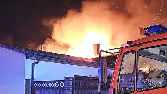 Ein Feuerwehrauto steht vor einer brennenden Fleischerei in Ummendorf.