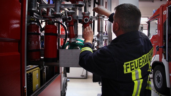 Frank Ochsner ist Bürgermeister und Feuerwehrgerätewart. Er kontrolliert das Equitment eines Feuerwehrautos.