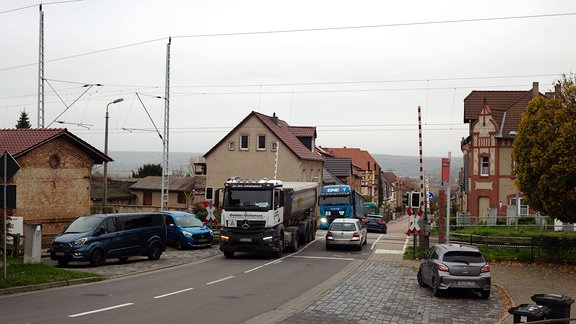 LKW und PKW überqueren Bahnübergang