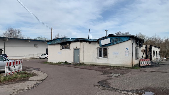 Eine zerstörte Lagerhalle mit weißer Fassade. 