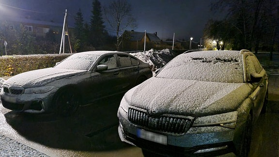 Eine leichte Schneedecke auf zwei Autos