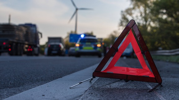 Ein Warndreieck steht an einer Unfallstelle.