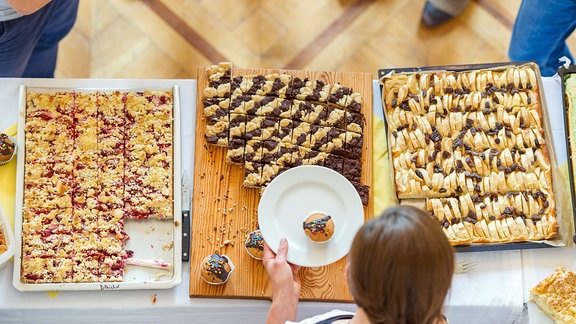 Selbstgebackener Kuchen wird an einem Kuchenstand an Besucher verkauft.