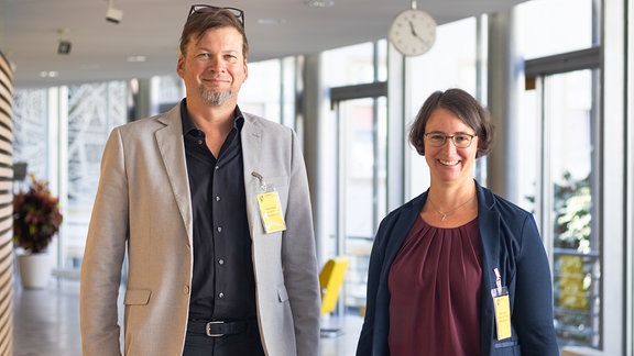 Ein Mann und eine Frau stehen nebeneinander und blicken in die Kamera.