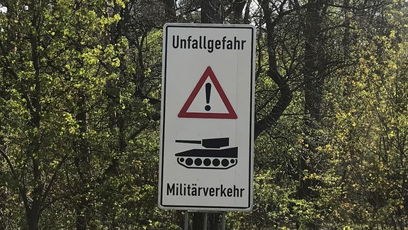 Straßenschild mit Warnung vor Militärverkehr