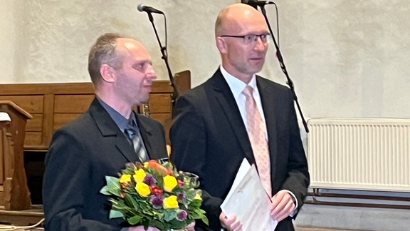 Der Vorsitzende des Vereins für krebskranke Kinder Harz, Every Kolle (links), bei der Verleihung des Bürgerpreis 2024 in der St. Sylvestrikirche in Wernigerode