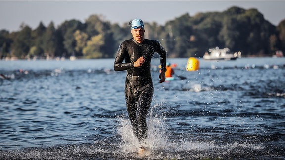 Tino Warnecke bei einem Wettkampf, durchs Wasser laufend