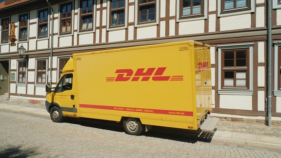 Der Wagen des Postdienstes DHL steht in einer ruhigen Straße von Wernigerode