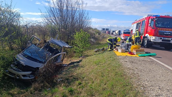 Ein silberfarbenes Auto liegt im Straßengraben der Autobahn 14.