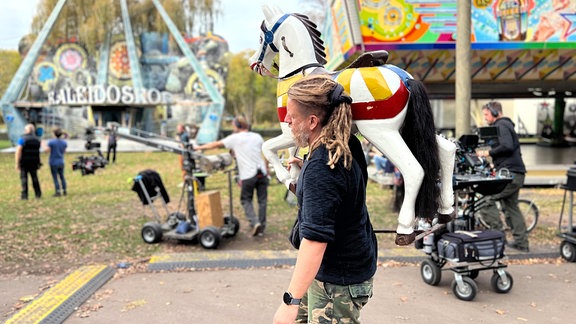 Dreharbeiten zu "Spuk unterm Riesenrad", ein Mann trägt ein Holzpferd