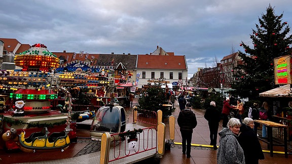 Fahrgeschäfte und Weihnachtsbaum auf dem Weihnachtsmarkt in Bernburg