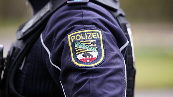 Logo der Polizei Sachsen Anhalt auf der Dienstkleidung eines*r Beamten*in