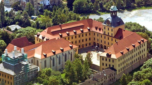 Die Schlossanlage aus der luft, ein mittiger Turm mit zwei Flügeln, davor ein weiterer Flügel des Schlosses