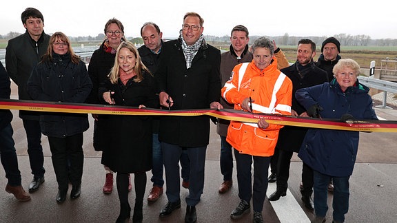  Lydia Hüskens (FDP), Ministerin für Infrastruktur und Digitales des Landes Sachsen-Anhalt (4.vr)) schneidet mit Vetretern aus Wirtschaft und Politik das Band zur Verkehrsfreigabe des A14-Teilabschnitts Tangerhütte-Lüderitz durch.