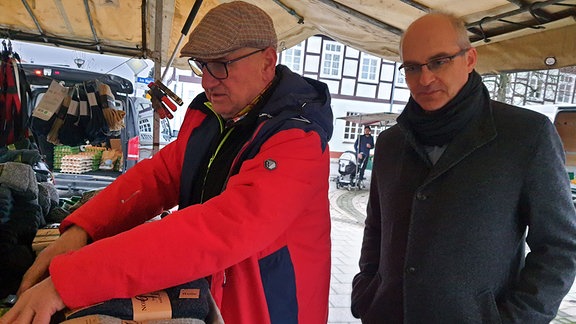 Marktmeister auf dem Wochenmarkt in Arendsee an einem Bekleidungsstand