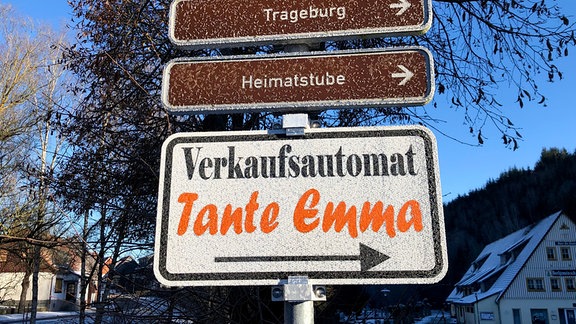 Ein Schild mit der Aufschrift "Verkaufsautomat Tante Emma" an einem Wegweiser.