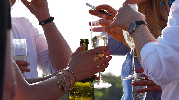 Partygäste halten Gläser mit Prosecco in den Händen