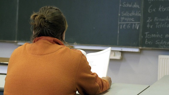 Analphabetin Renate mit einem Lehrbuch für Analphabeten in einem Schulungsraum des Vereins - Lesen und Schreiben e.V. - in Berlin-Neukölln.