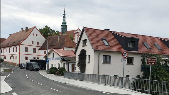 Eine frisch sanierte Straße mit einer Brücke kurz vor der Eröffnung.