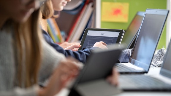 Schülerinnen und Schüler nehmen im Klassenzimmer einer 9. Klasse der Gemeinschaftsschule Leutenbach am Geografieunterricht mit Hilfe von Laptops und Tablets teil.