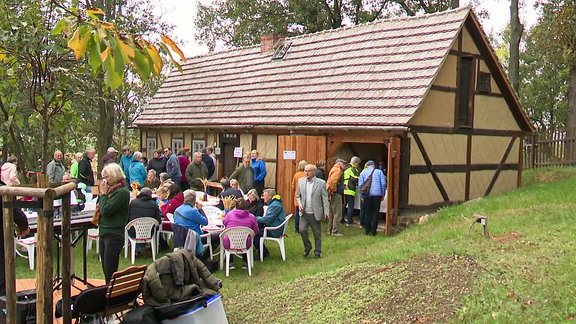 Menschen vor  einem Fachwerkhaus