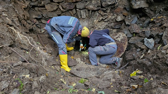 Mitarbeiter einer Firma zur Bergsicherung arbeiten in einem Areal in einem Waldstück