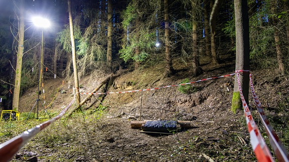 Flutlichter und Absperrband in Waldstück