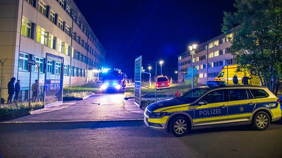 Das Tor der umzäunten Erstaufnahmeeinrichtung Schneeberg steht offen, ein Feuerwehrfahrzeug fährt auf das Tor zu.