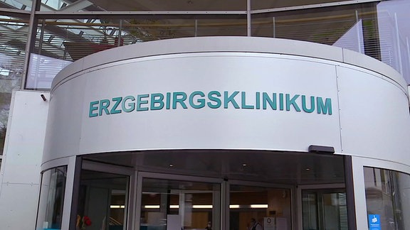 Mintfarbene Schrift auf metallic-grauem Untergrund mit dem Schriftzug 'Erzgebirgsklinikum'