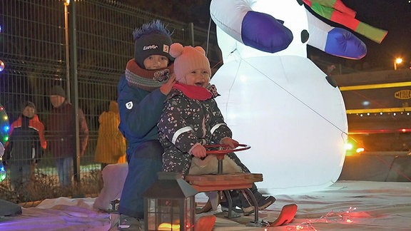 Zwei Kinder sitzen auf einem mini-Gefährt beim Truckerfest Lichterfest in Annaberg.