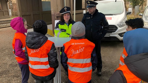 Zwei Bundespolizisten im Gespräch mit einer Gruppe von Schülern.