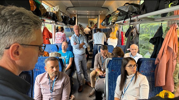 In einem Eisenbahnzug sitzen Teilnehmer des European Peace Ride 2024.