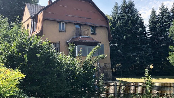 Ein Haus inmitten von Bäumen und Hecken