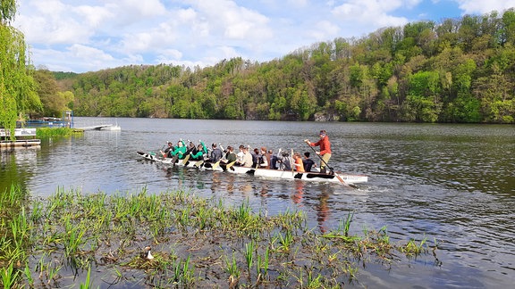 Ein Drachenboot fährt in der Nähe des Ufers auf der Talsperre Kriebstein.