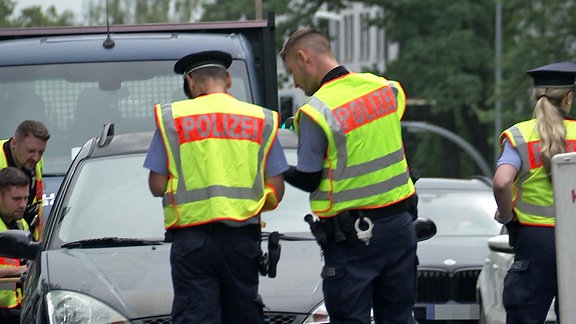 Polizisten mit gelben Westen kontrollieren den Straßenverkehr