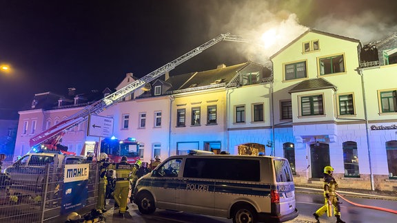 Die Feuerwehr löscht einen Brand auf einem Hausdach