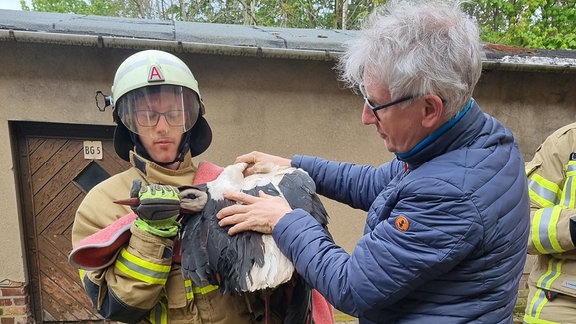 Ein Storch wird von Einsatzkräften der Feuerwehr gerettet.