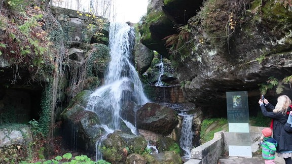 Eine Frau und ein Kind stehen an einem Wasserfall