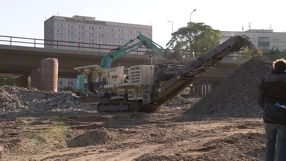 Ein großes Baugerät - eine Brechanlage - zerkleinert Steine